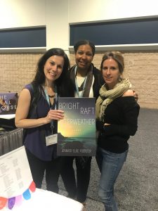 Jennifer Elise Foerster and colleagues stop by the booth to proudly pose with a poster of her most recent collection.