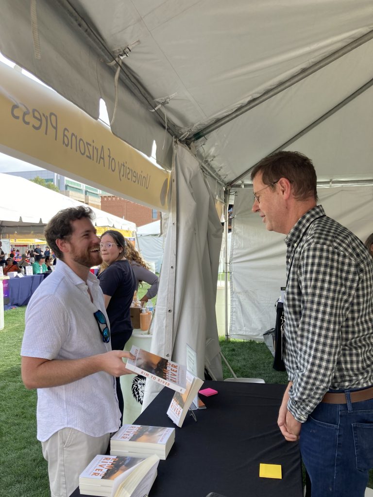 A University of Arizona Press author discusses his book with a festival attendee.