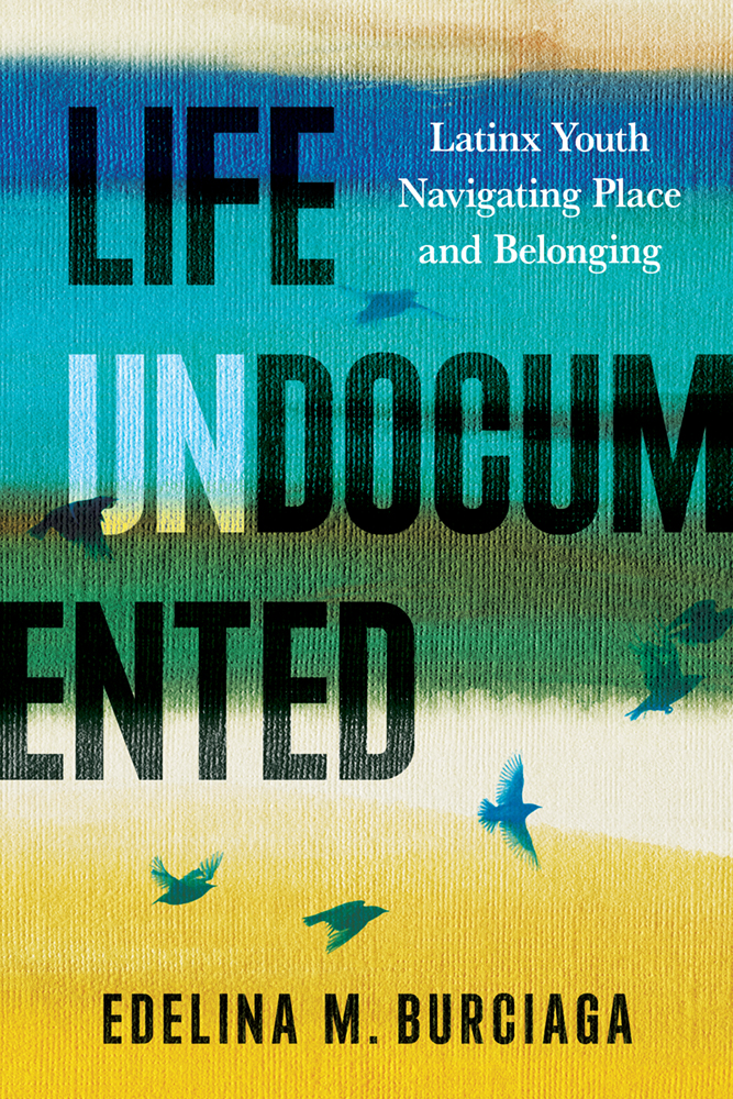 Book cover for "Life Undocumented" by Edelina M. Burciaga, featuring horizontal painted bands of blue, green, yellow, and white with silhouettes of birds flying across the textured background.