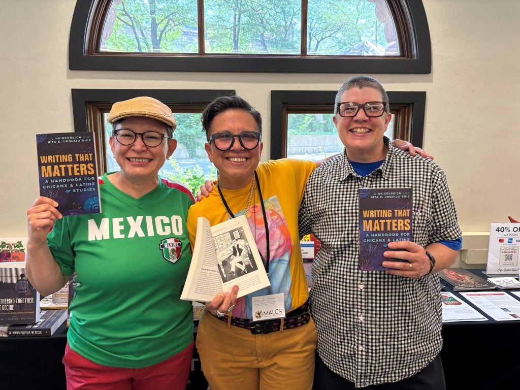 Writing That Matters authors Rita E. Urquijo-Ruiz and L. Heidenreich stand with illustrator Anel Flores at the 2026 MALCS Summer Institute